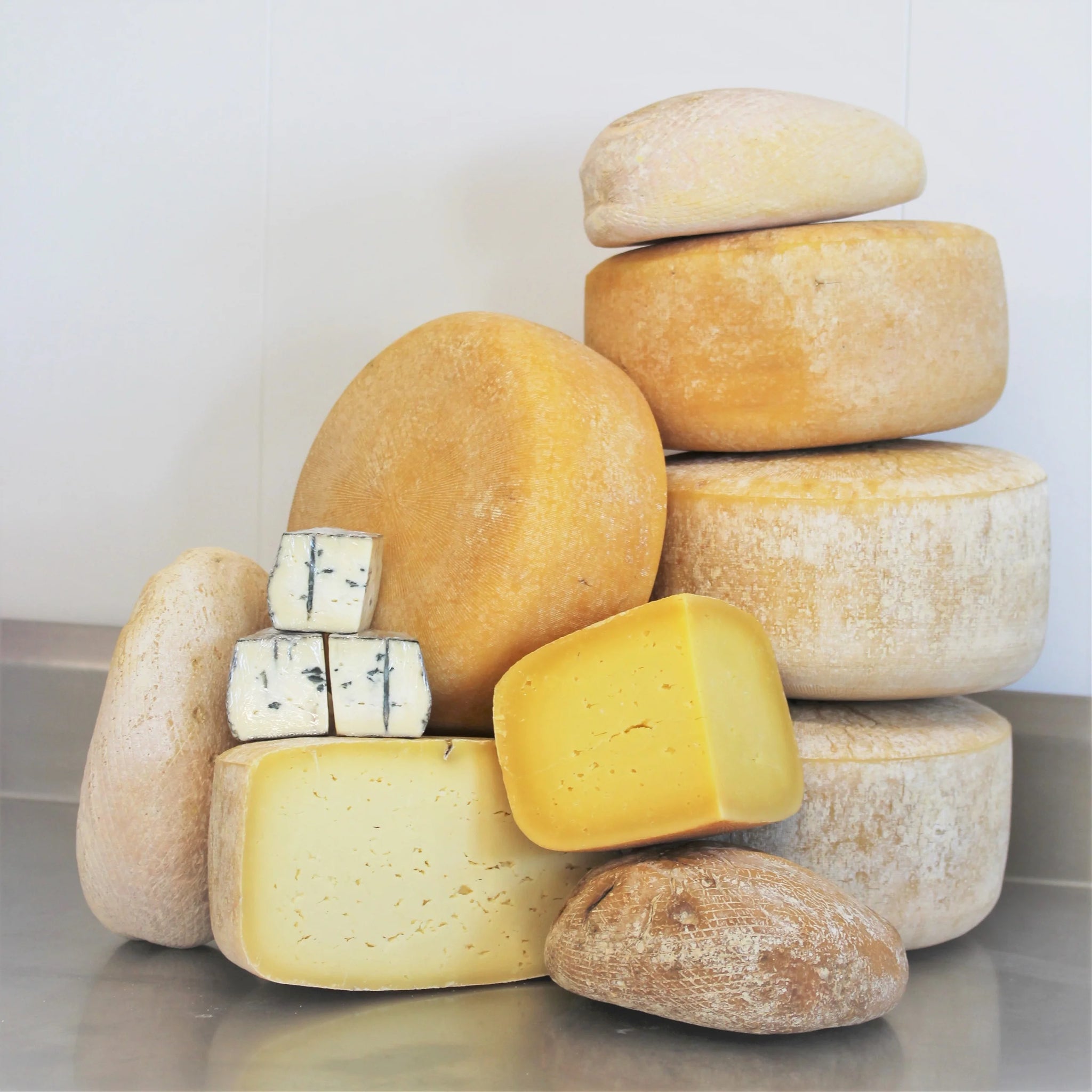 A winter seasonal cheese box from Lost Lake Farm, showing three wedges of farmstead cheese, cow postcards, and a member certificate.