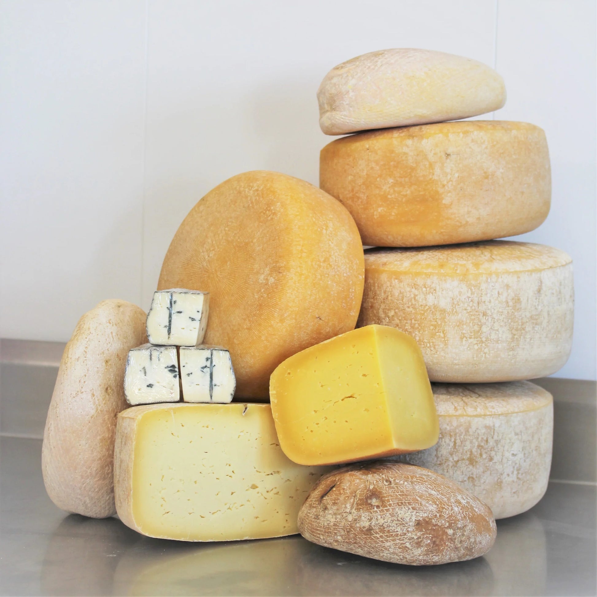 A winter seasonal cheese box from Lost Lake Farm, showing three wedges of farmstead cheese, cow postcards, and a member certificate.